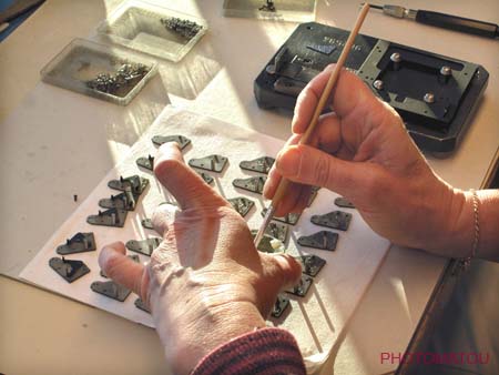 030 DETAIL MAINS D'UNE EMPLOYEE REALISANT LE MONTAGE MANUEL DES BOITIERS 203-205